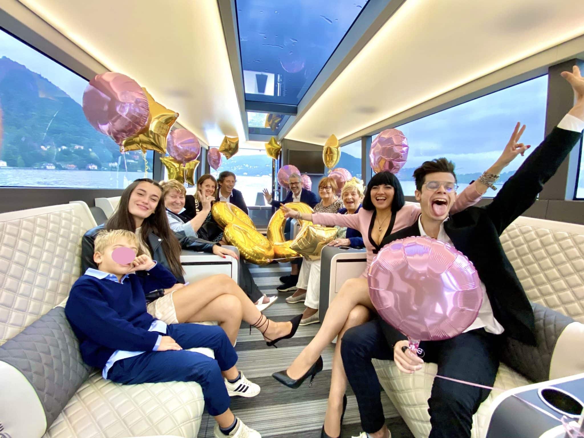 Family and friends smiling and happy for having a lake como private tour on a luxury private boat as brithday cruise for birthday